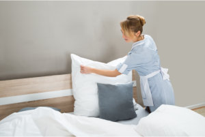 female housekeeper arranging the bed